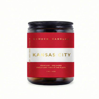 red white and gold Austrian Flag inspired label on candle reading "Kansas City" with black lid on white background