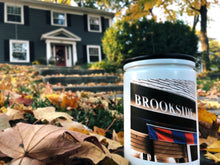 Load image into Gallery viewer, KCMOCO. Brookside Blvd. Candle in KC Collection Jar: White glass jar with photo label depicting Brookside Shops awning, with black bamboo lid, Brookside home in background.
